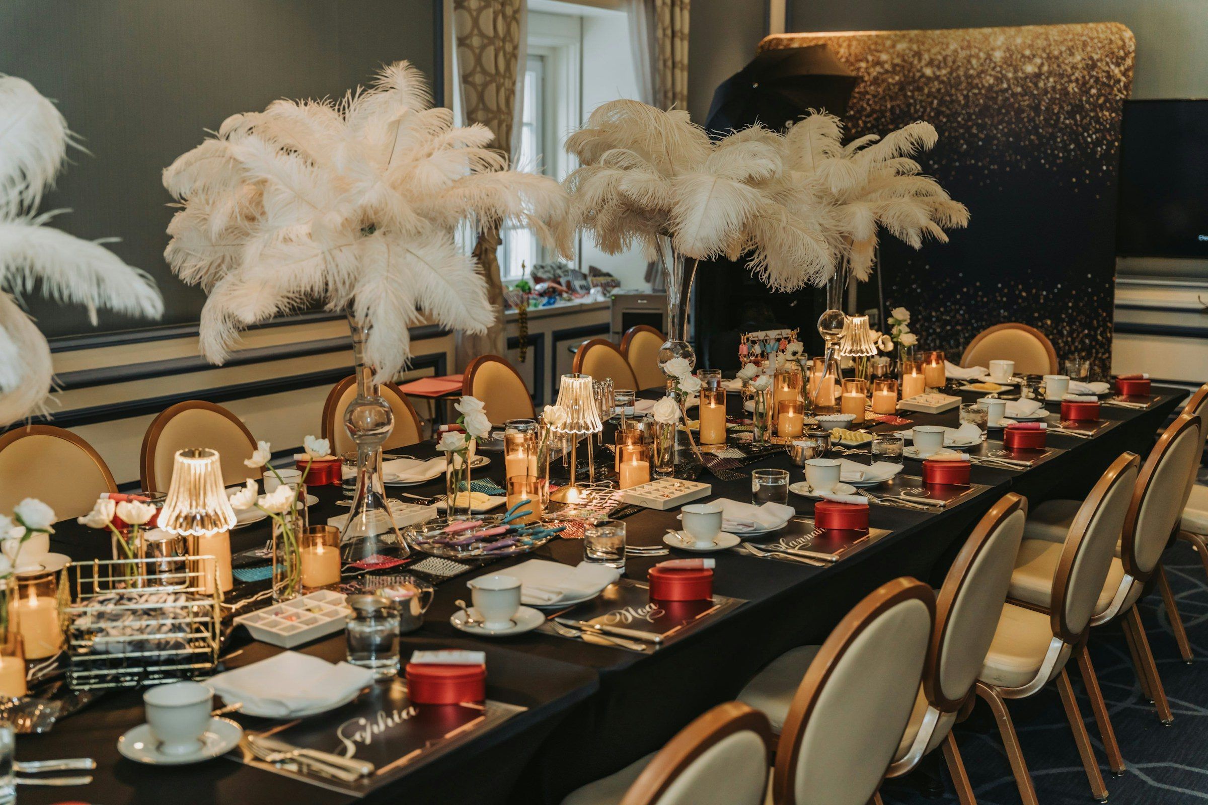 A formal table dressed with feather centrepieces, candles and place settings