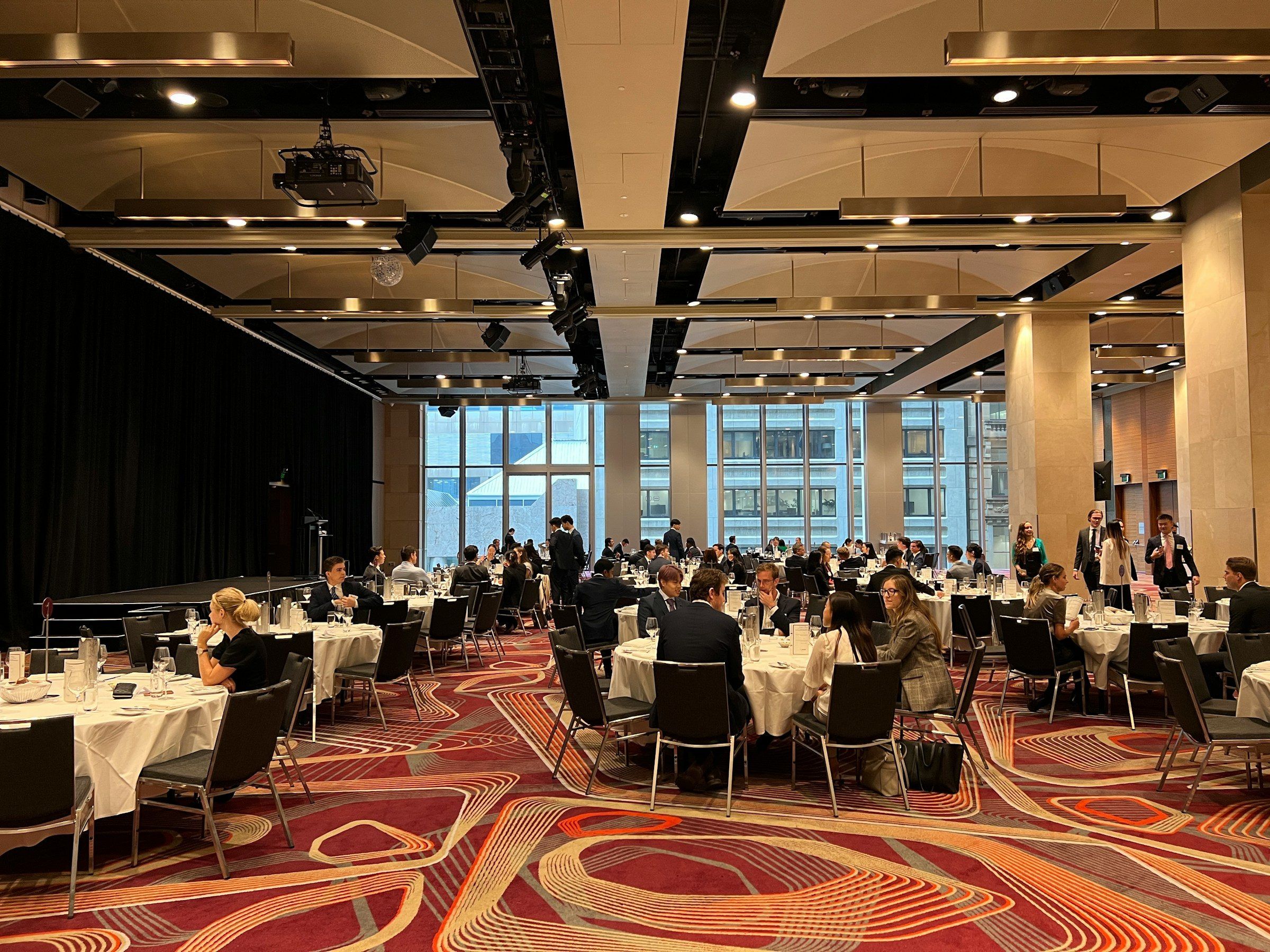 Guests seated at round tables in a contemporary dining room