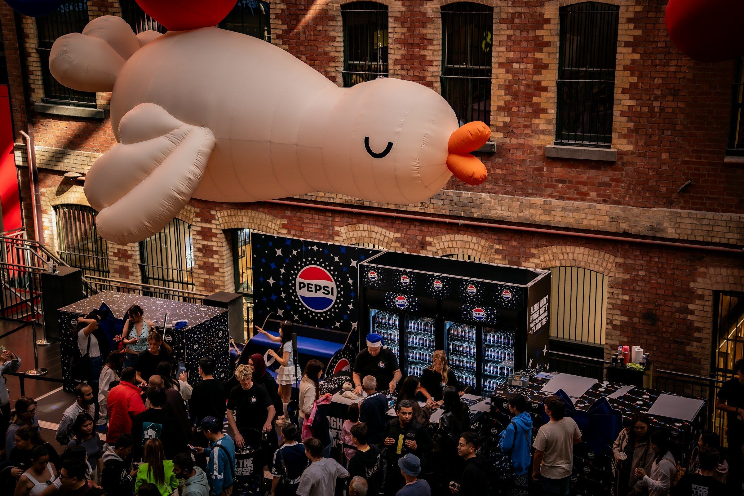 A giant inflatable above a crowded brand activation
