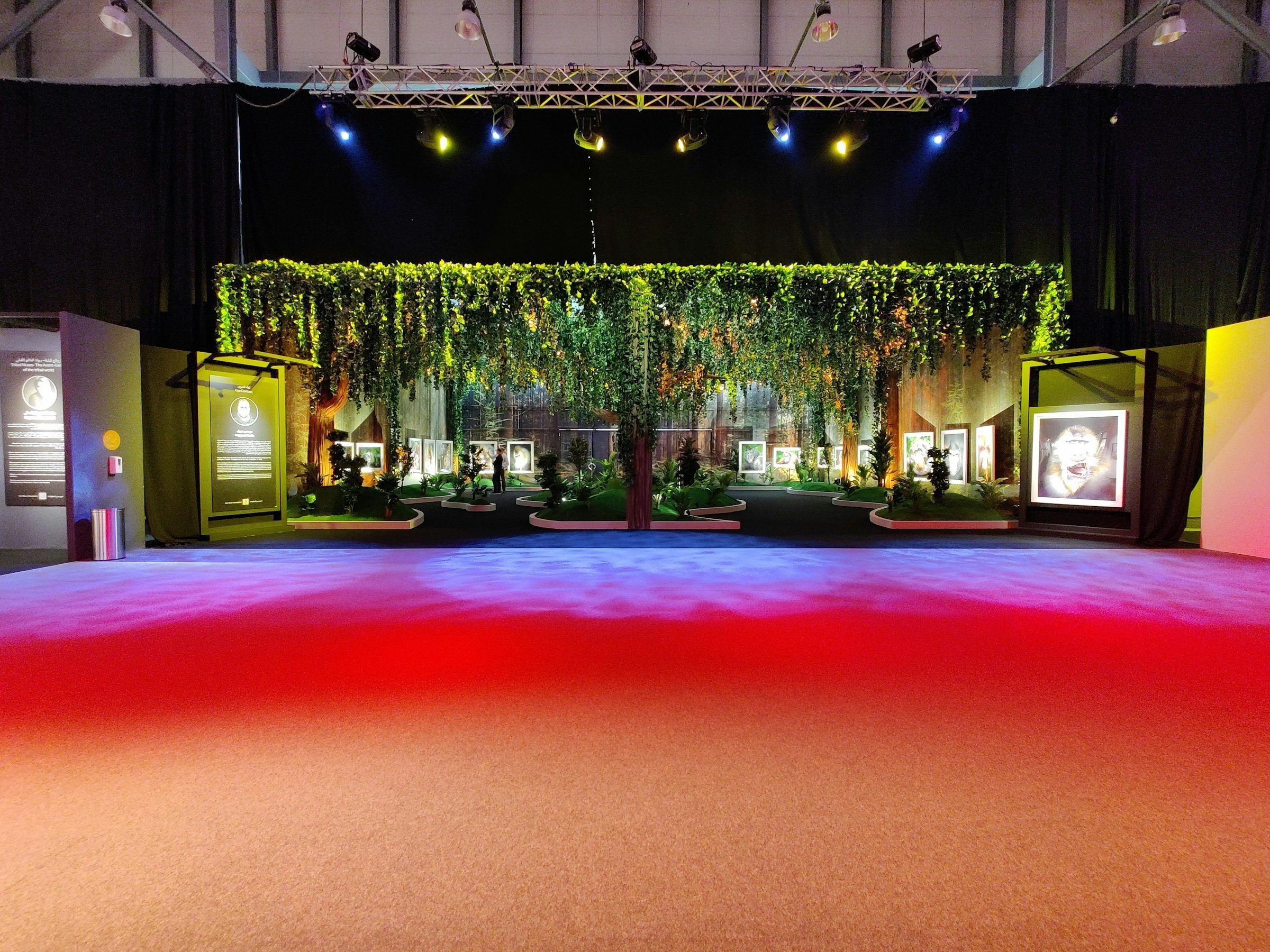 A staged hall with a hanging-garden backdrop and a red carpet