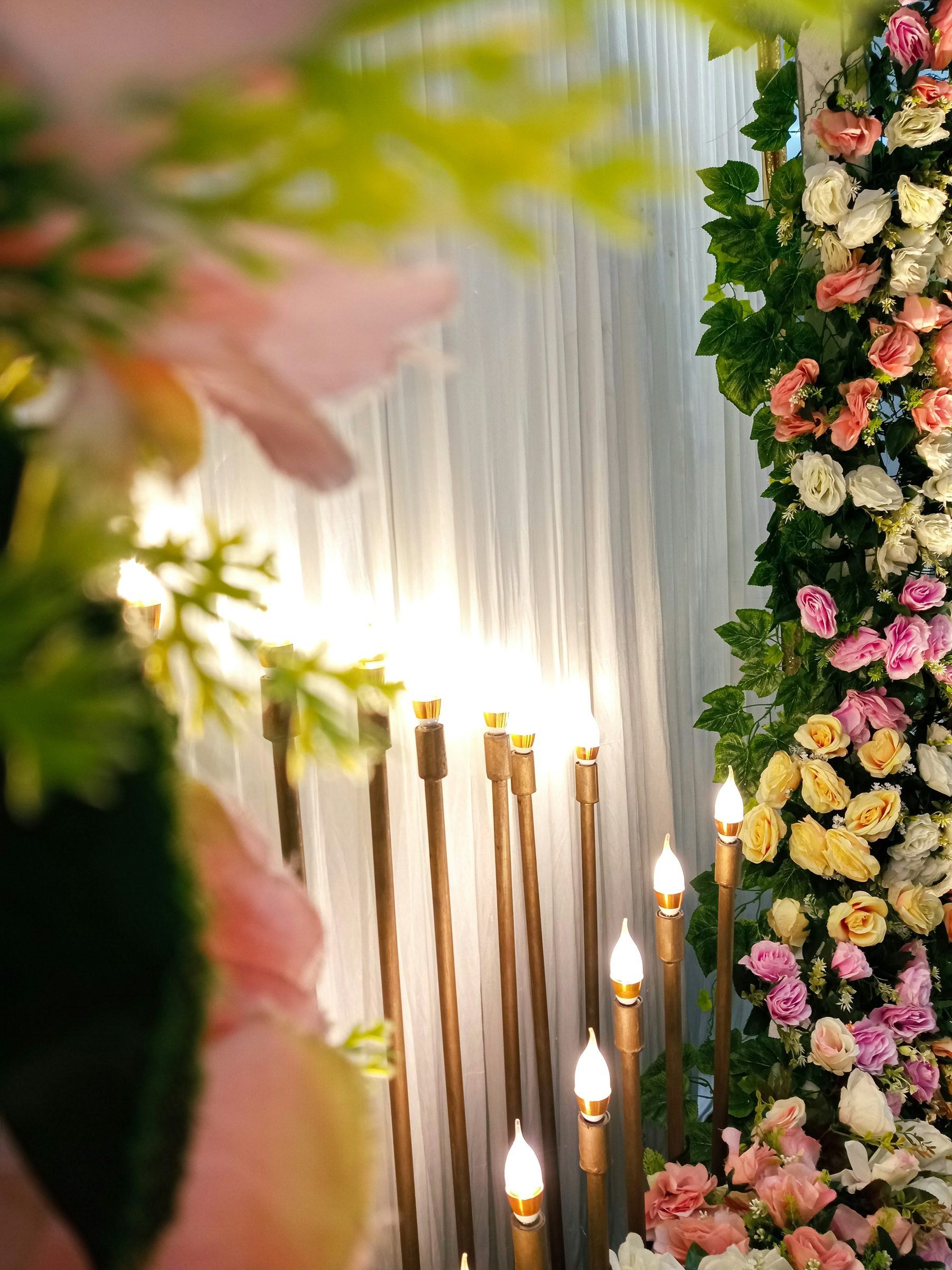 Climbing florals and candles in a soft, luminous installation